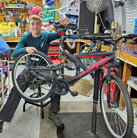 A man in a garage with a bicycle.