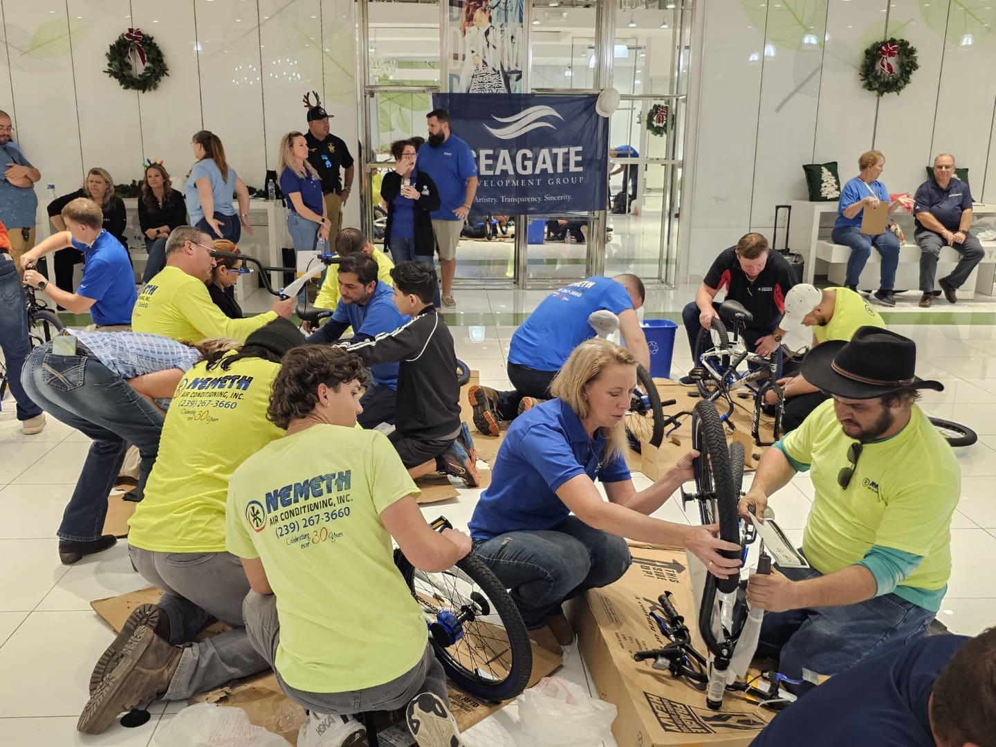 A group of people building bicycles in an indoor area.